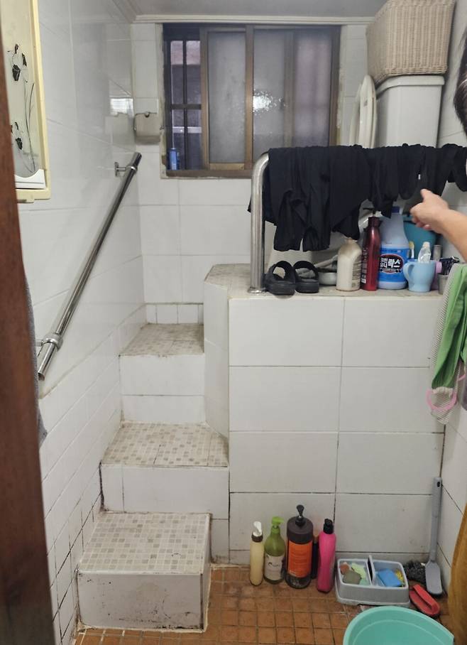 서울 성동구의 나경호(가명)씨의 반지하 주택 화장실에서 변기를 이용하려면 계단 네 칸을 올라야 한다. 나씨는 계단을 내려오다가 넘어진 적이 있다. 최근 성동구청의 지원으로 계단 옆에 손잡이를 설치했다. 채윤태 기자