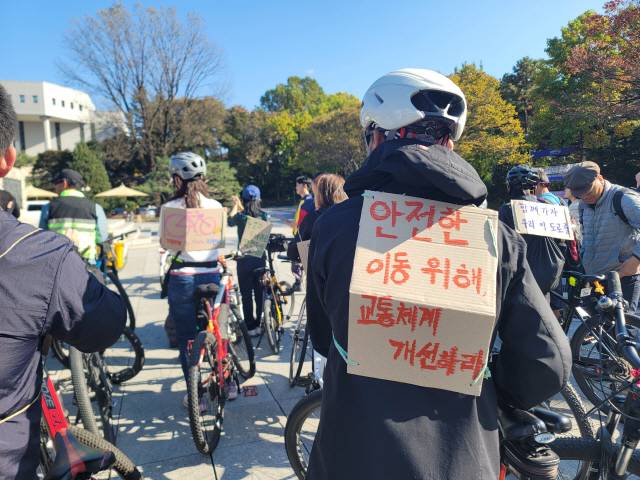 ▲ 제3회 2025년 함께 자전거 행사가 1일 강원대에서 열렸다. 두바퀴로가는세상 회원인 송인모(71) 씨는 ‘안전한 이동 위해 교통체계 개선하라’라는 문구가 적힌 종이 피켓을 등에 멨다.  이설화 기자