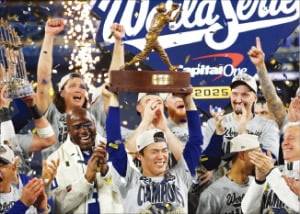 2일(한국시간) ﻿미국 프로야구 메이저리그 월드시리즈﻿에서 우승한 LA 다저스의 ﻿승리투수 야마모토 요시노부(가운데)가 동료들의 축하를 받으며 MVP 트로피를 들어 보이고 있다.  AFP연합뉴스