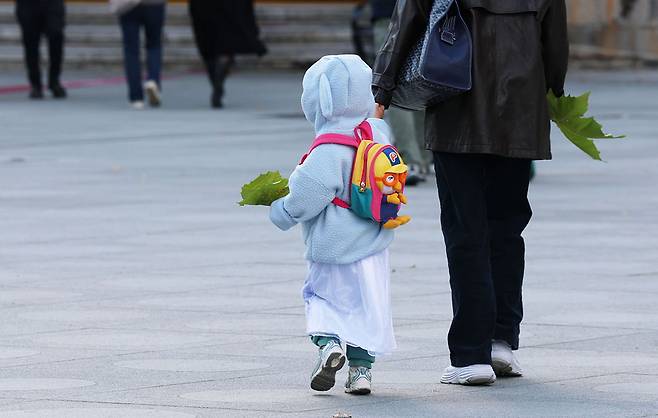 서울을 비롯한 전국 곳곳에 한파주의보가 발효된 2일 서울 종로구 광화문 광장 에서 따뜻한 옷차림을 한 어린이가 나뭇잎을 들고 걸어가고 있다. 한수빈 기자