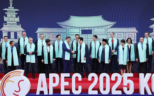 이재명 대통령이 1일 경주 화백컨벤션센터(HICO)에서 열린 아시아태평양경제협력체(APEC) 정상회의 기념촬영에서 시진핑 중국 국가주석과 악수하고 있다. 앞줄 왼쪽부터 하사날 볼키아 브루나이 국왕, 마크 카니 캐나다 총리, 가브리엘 보리치 칠레 대통령, 시진핑 중국 국가주석, 이 대통령, 프라보워 수비안토 인도네시아 대통령, 다카이치 사나에 일본 총리, 안와르 이브라힘 말레이시아 총리. [경주 김호영 기자]