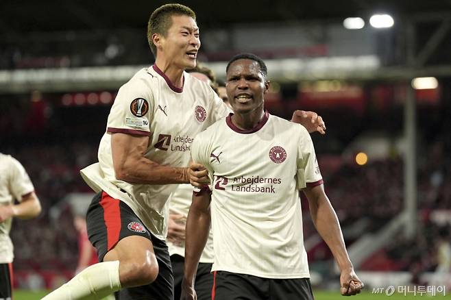 [노팅엄=AP/뉴시스] 미트윌란(덴마크)의 조규성(왼쪽)이 2일(현지 시간) 영국 노팅엄의 시티 그라운드에서 열린 2025-26 유럽축구연맹(UEFA) 유로파리그(UEL) 리그 페이즈 2차전 노팅엄 포레스트(영국)와의 경기 전반 18분 우스만 디아오의 선제골에 함께 환호하고 있다. 조규성은 67분을 소화했고, 미트윌란은 3-2로 승리해 2승을 기록했다. 2025.10.03. /사진=민경찬