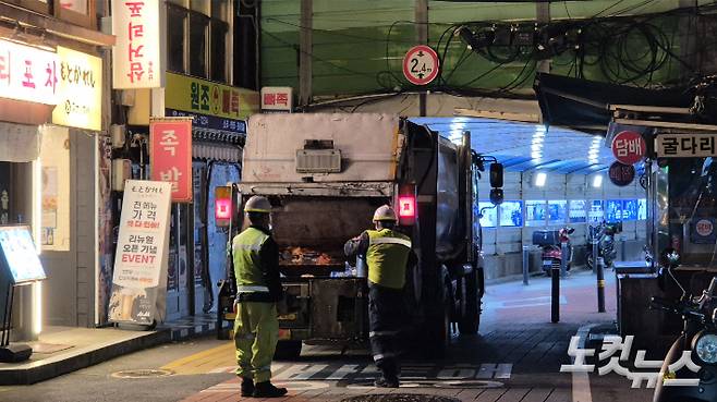 지난달 21일 새벽 서울 용산구의 한 식당가 골목에서 환경미화원들이 생활폐기물 처리 작업을 하고 있다. 송선교 기자