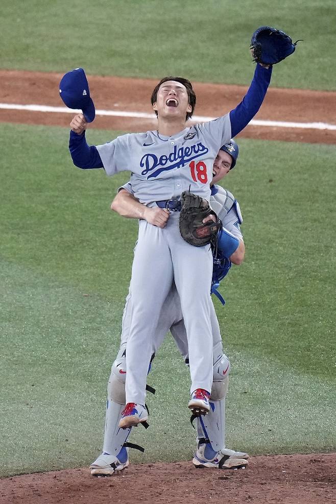 WS 2연패 이끈 다저스 배터리 - 로스앤젤레스(LA) 다저스 포수 윌 스미스(뒤)가 1일(현지 시간) 캐나다 토론토의 로저스 센터에서 열린 2025 메이저리그 월드시리즈(WS·7전4선승제) 7차전에서 토론토 블루제이스를 꺾고 우승한 후 역투한 마무리 투수 야마모토 요시노부를 안아 올리고 있다. 스미스는 연장 11회 초 역전 1점 홈런으로 쳐 팀의 5-4 승리를 이끌었고, 야마모토는 팀 4승 중 3승을 책임졌다. 2025.11.02 토론토 AP 뉴시스