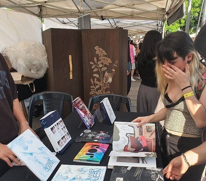 '한인 문화의 날' 행사장 내 한국콘텐츠진흥원 부스에서 우는 팬 (부에노스아이레스=연합뉴스) 김선정 통신원 = 아르헨티나의 수도 부에노스아이레스의 팔레르모 공원에서 2025년 한인 문화 행사 '하루 페스트가'가 2일(현지시간) 개최됐다. 한국콘텐츠진흥원은 별도의 부스를 마련해 K-POP 앨범전시회를 기획했다. 자신이 좋아하는 아이돌 그룹의 사진을 발견한 팬이 감격해 울고 있다. 2025.11.3 sunniek8@yna.co.kr