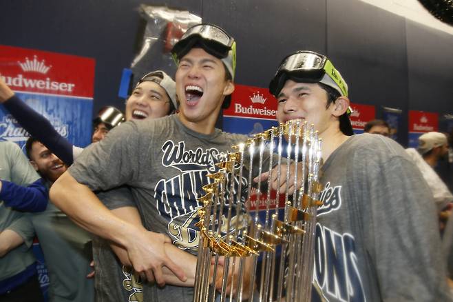 Oct 31, 2025; Toronto, Ontario, CAN; Los Angeles Dodgers two-way player Shohei Ohtani (17) and pitcher Yoshinobu Yamamoto (18) and pitcher Roki Sasaki (11) celebrate with the Commissioner's Trophy in the clubhouse after defeating the Toronto Blue Jays in the 2025 MLB World Series at Rogers Centre. Mandatory Credit: John E. Sokolowski-Imagn Images







<저작권자(c) 연합뉴스, 무단 전재-재배포, AI 학습 및 활용 금지>
