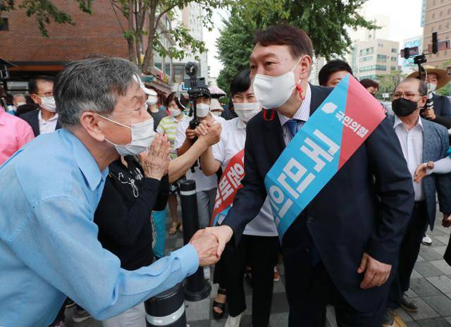 윤석열 전 대통령이 대선 후보 시절이던 2021년 8월 3일 오후 서울 은평구 응암역 앞에서 국민의힘 당원 가입을 독려하는 홍보 활동을 위해 이동하며 지지자들과 악수하고 있다. 오대근 기자