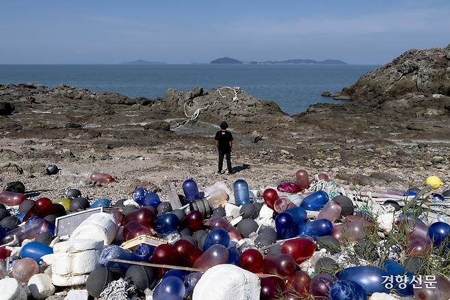 최황 녹색연합 자연 생태팀 활동가가 10월 1일 해양 쓰레기가 가득 쌓인 전남 신안군 임자면의 한 해안에서 바다를 바라보고 있다. 형형색색의 폐어구들과 쓰레기가 가득 쌓인 모습이 유네스코 세계 자연유산 구역이라는 게 믿기지 않았다. 마치 만들어 놓은 세트장 같았다. 신안 l 문재원 기자