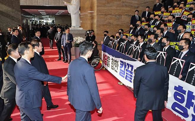 이재명 대통령이 4일 내년도 정부 예산안에 대한 시정연설을 하기 위해 서울 여의도 국회에 도착해 피켓시위를 하는 국민의힘 의원들 앞을 지나고 있다. 국민의힘 의원들은 추경호 전 원내대표에 대한 내란특검팀의 영장청구에 반발하며 야당 탄압 중단을 촉구했다. [국회사진기자단]