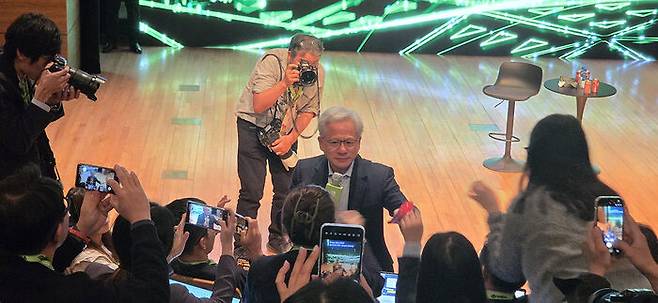 지난달 31일 경북 경주 예술의전당 원화홀에서 열린 '2025 APEC 경주 엔비디아 기자간담회'에서 젠슨 황 엔비디아 CEO가 기자들에게 과자를 나눠주고 있다. (사진 촬영=김관진 기자)