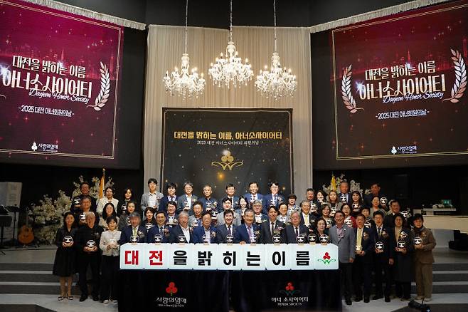 노선호 회장과 아너소사이어티클럽 회원들이 ‘대전을 밝히는 이름 아너소사이어티’를 제목으로 한 2025 대전 아너회원의 날에 단체 사진을 찍고 있다.
