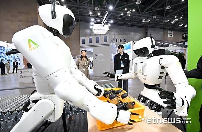 로보월드 2025가 5일 경기 고양시 킨텍스에서 열렸다. 올해로 20회를 맞은 이번 전시에는 피지컬AI에 대한 정부·민간 기업의 관심이 높아진 가운데 300여 국내 기업과 50여 개의 해외 기업이 참가해 역대 최대 규모로 열렸다. 참관객이 에이로봇의 앨리스모바일(왼쪽)와 앨리스4의 협동작업 시연을 살펴보고 있다.  이동근기자 foto@etnews.com