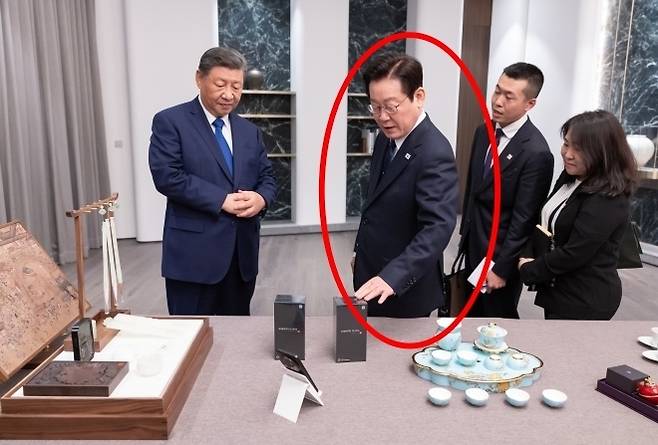 이재명 대통령과 시진핑(왼쪽) 중국 국가주석이 1일 경북 소노캄 호텔에서 국빈만찬 전 서로를 위해 준비한 선물을 보고 있다. 시 주석이 선물한 샤오미 휴대전화를 이 대통령이 만져보고 있다. 연합뉴스