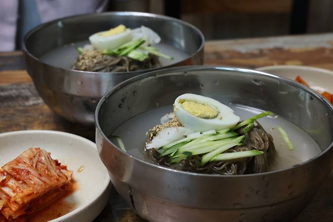 ▲&nbsp;인천 옹진군 백령도 진촌리 시골메밀칼국수의 냉면. 고명은 오이, 달걀 반쪽, 무가 전부다. 얼음도 없다. 하지만 사골 맛이 느껴지는 국물에다 이가 차가울 정도로 시원한 냉면 맛은 더할 나위 없이 좋다. 메일은 백령도산만 쓰고 있다. 주인장의 자부심이 담긴 냉면 한 그릇은 단순한 음식이 아닌 삶이 담긴 음식이다. /양진수 기자 photosmith@incheonilbo.com