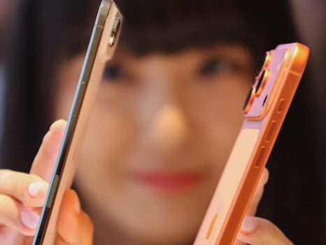 한 여성이 역대 가장 얇은 아이폰 에어(왼쪽)와 아이폰17 PRO를 들어 얇기를 비교하고 있다. [사진, 연합]