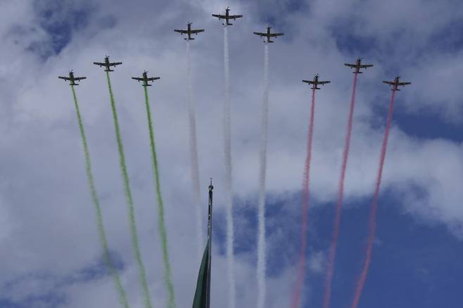 [멕시코시티=AP/뉴시스] 16일(현지 시간) 멕시코 수도 멕시코시티에서 열린 독립기념일 연례 군사 퍼레이드에서 곡예비행단이 멕시코 국기 색깔의 연막을 뿜으며 축하 비행하고 있다. 2025.09.17.