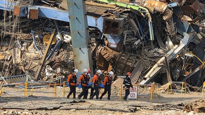 구급대원들이 7일 오전 한국동서발전 보일러 타워 붕괴 사고 현장에서 발견된 노동자를 옮기고 있다. 울산소방본부 제공