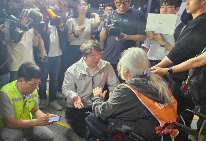 지난 5월, 전장연의 시청역 점거 당시 박경석 전장연 상임대표(주황색 조끼를 입은 장발의 남성)와 논쟁하는 문성호 서울시의원(중앙에 무릎 꿇고 이야기하는 사람)