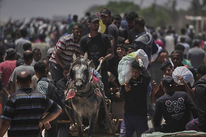 팔레스타인 가자지구 남부 라파 내 현지인들이 지난 1일(현지시간) 미국 구호단체 가자인도주의재단(GHF)이 제공한 식량과 구호물자를 받고 있다. 뉴시스