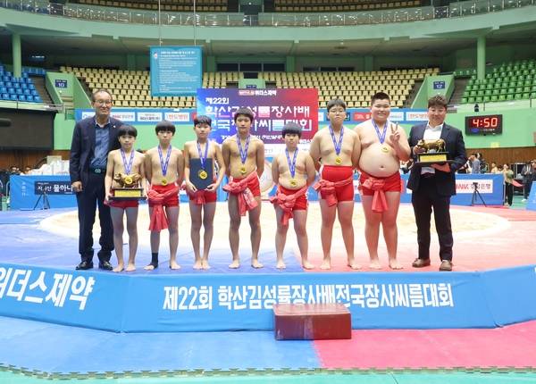 마산실내체육관에서 8일 열린 '제22회 학산김성률장사배전국장사씨름대회' 초등학교부 단체전 우승을 차지한 북성초등학교가 손재근 대한씨름협회 부회장(왼쪽 첫째), 황태혁 감독(오른쪽 첫째)과 우승 기념 사진을 찍고 있다. /대한씨름협회