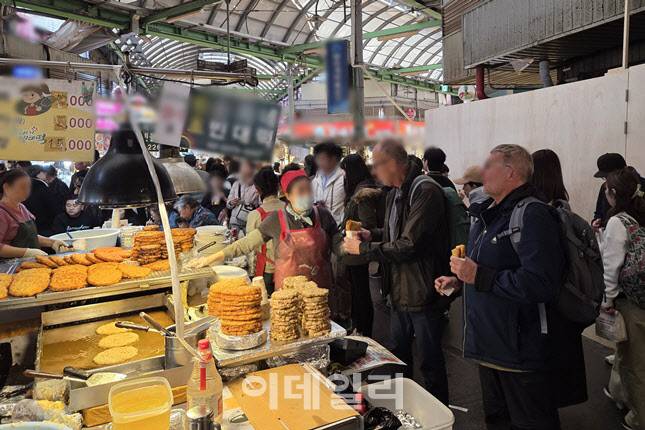 광장시장 대표 먹거리 중 하나인 전 노점. 바삭한 전을 들고 서서 먹는 외국인 관광객들이 많았다 (사진=한전진 기자)