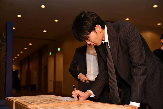 ‘바둑 황제’ 신진서 9단 30주년 기념 바둑판에 사인하고 있다. 한국기원 제공