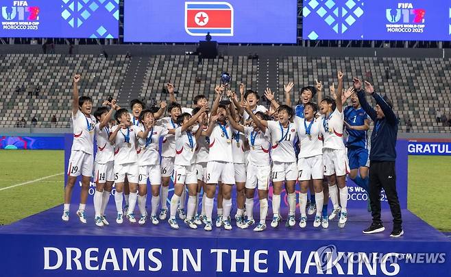 2025 U-17 여자 월드컵 우승 트로피를 들어올리는 북한 U-17 여자 축구 대표팀 선수들  [EPA=연합뉴스]