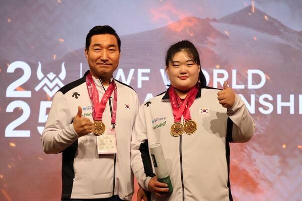 박혜정(22·고양시청)이 최종근 고양시청 감독(현 대한역도연맹 부회장이자, 대표팀 총괄단장)과 함께 11일 노르웨이 포르데에서 열린&nbsp;국제역도연맹(IWF) '2025 세계역도선수권대회' 여자 86kg+급 인상 125kg, 용상 158kg, 합계 283kg으로 3관왕을 달성한 뒤 메달과 함께 사진을 찍고 있다. /사진=대한역도연맹