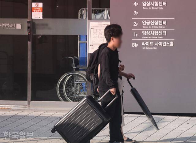 9월 서울 시내에 위치한 병원의 임상시험센터에서 병동 합숙을 마친 남성 참여자들이 짐을 들고 건물 밖으로 나오고 있다. 최주연 기자