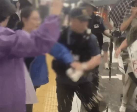 A woman is seen throwing coffee toward an anti-China rally held in Seoul in a video that went viral on Nov. 10, 2025. [SCREEN CAPTURE]