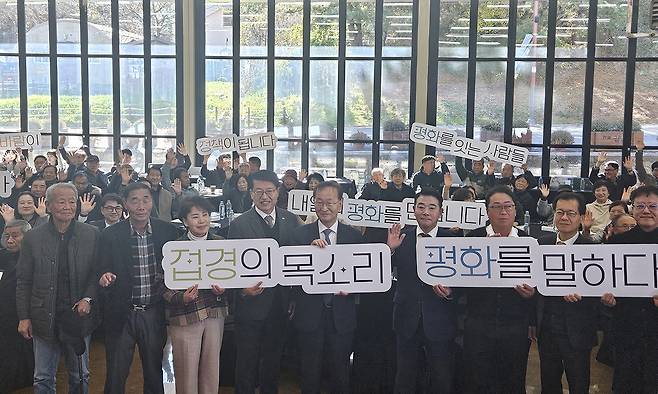 김남중 통일부 차관(앞줄 가운데)이 10일 경기도 파주 캠프그리브스에서 북한 접경 지역 주민들의 고충을 듣는 행사에서 한반도 평화를 기원하는 내용의 팻말을 들고 참석자들과 함께 기념 촬영을 하고 있다. 파주=연합뉴스