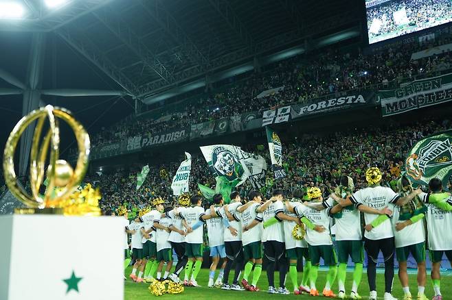 전북 선수들이 8일 전주성에서 진행된 우승 행사 도중 트로피를 배경으로 홈팬들과 함께 특유의 ‘오오렐레’ 세리머니를 하며 열기를 고조시키고 있다. 사진제공|전북 현대