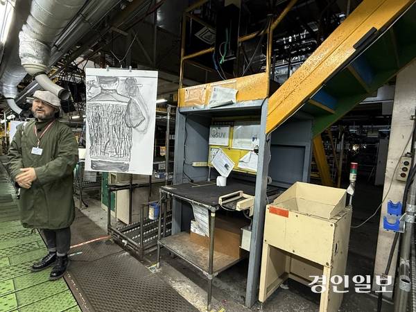 한국지엠 부평2공장 조립공장 내 컨베이어벨트에 전시된 김은희 작가의 드로잉. 드로잉이 있는 자리는 노동자가 일하던 그 자리다. 경인콜렉티브 오석근 작가가 작품의 의미를 설명하고 있다. 2025.11.7 /박경호기자 pkhh@kyeongin.com