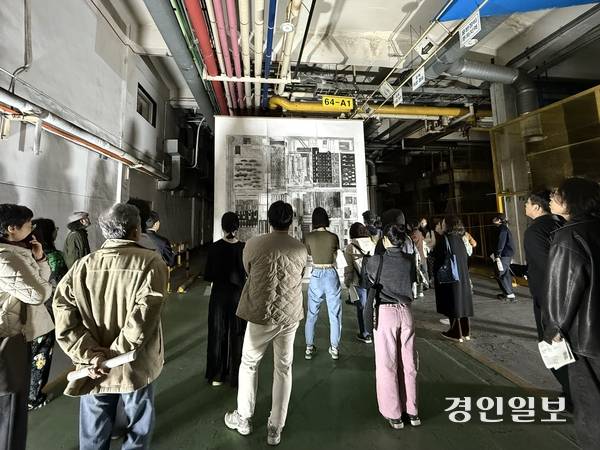 한국지엠 부평2공장 자체공장 내 전시된 대형 드로잉 작품(‘플랜트그라피_모터피아’)을 관람객들이 바라보고 있다. 2025.11.7 /박경호기자 pkhh@kyeongin.com