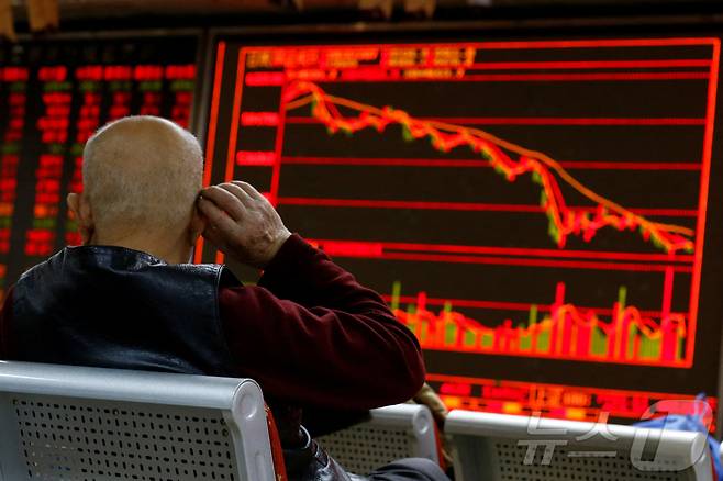 7일 중국 베이징의 한 중개사무소에서 투자자가 주식 정보를 보여주는 게시판 앞에 앉아 있다. 2018.12.07 ⓒ 로이터=뉴스1 ⓒ News1 유수연 기자