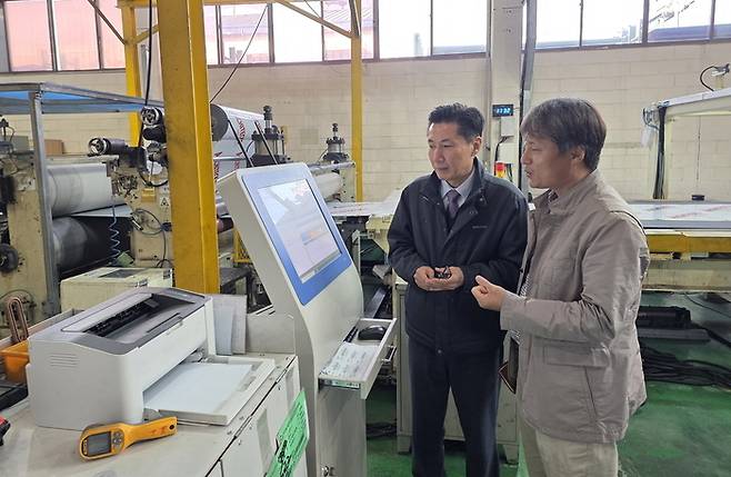 스마트공장으로 탈바꿈한 홍성산업 내 작업 공간을 김병식 홍성산업 대표(왼쪽)와 김재용 삼성전자 스마트공장지원센터 위원이 살펴보고 있다. 삼성전자