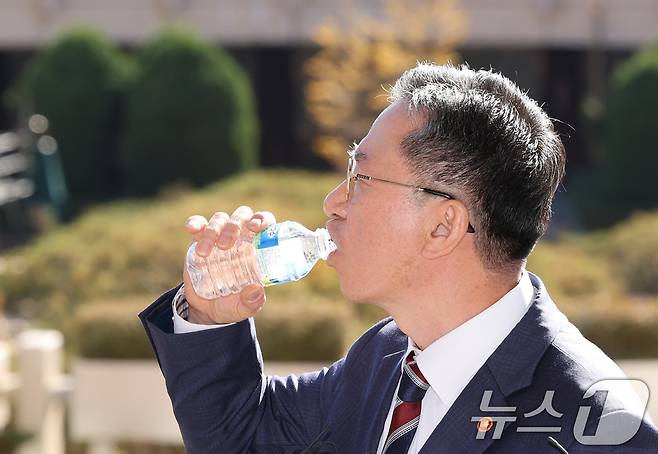 정성호 법무부 장관이 지난 10일 오전 경기 정부과천청사 법무부 출입구에서 최근 검찰이 대장동 개발비리 의혹 사건 1심 선고에 대한 항소를 포기한 것과 관련한 입장을 밝히던 중 목을 축이고 있다. 2025.11.10/뉴스1 ⓒ News1 장수영 기자