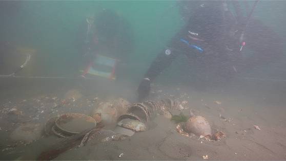 Divers work to retrieve artifacts seen near the shipwreck of Mado wreck No. 4, the only existing ship from the Joseon Era (1392-1910), off the coast of Mado Island, near South Chungcheong's Taean. [KOREA HERITAGE SERVICE]