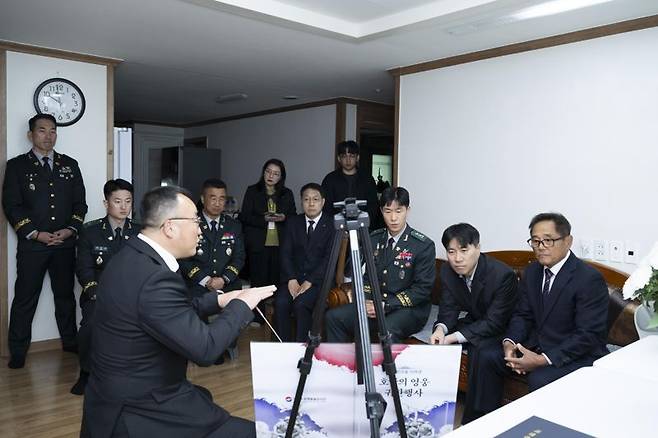 국방부유해발굴감식단장 직무대리 조해학 중령(육군 ·오른쪽)이 유가족 등 행사 참석자들에게 고 박석호 일등중사의 참전 경로, 유해발굴 당시 일화 등을 설명하고 있다. 국방부 제공