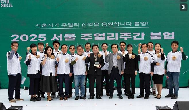 서울특별시가 주최하고 서울주얼리지원센터와 서울 주얼리홍재영 한국보석협회 명예회장(앞줄 오른쪽 세번째)이 지난 달 중순 서울 종로 돈화문로 일대에서 열린 '2025 서울 주얼리주간 붐업(Boom-UP)' 행사 무대에서 관계자들과 기념활영을 하고 있다.