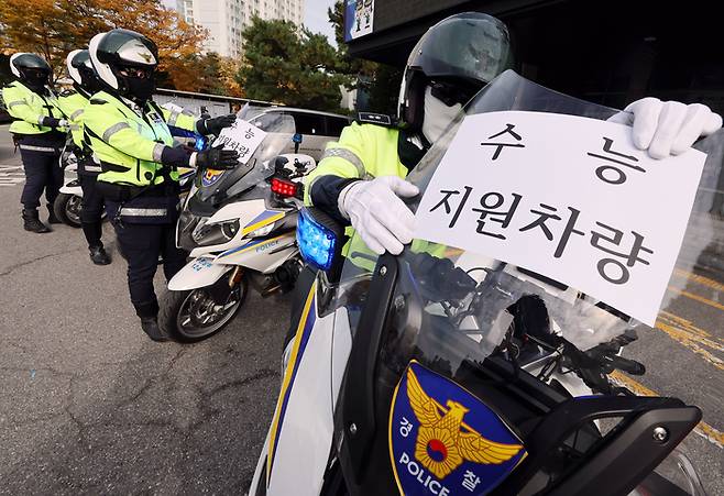 2026학년도 대학수학능력시험을 이틀 앞둔 11일 오후 경기 수원영통경찰서에서 경찰관들이 수능 특별 교통관리에 사용될 경찰 오토바이에 안내문을 부착하고 있다. [연합뉴스]