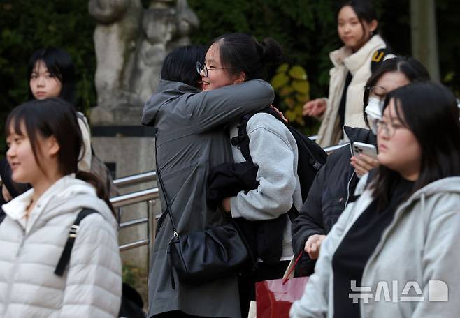 [서울=뉴시스] 홍효식 기자 = 2026학년도 대학수학능력시험을 마친 수험생이 13일 오후 서울 마포구 홍익대학교사범대학부속여자고등학교에서 가족과 포옹하고 있다. 2025.11.13. yesphoto@newsis.com