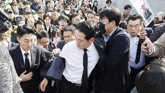 장동혁 국민의힘 대표가 6일 광주를 찾아 국립 5?18민주묘지를 참배하기 위해 들어서자 광주전남촛불행동 회원들이 몸싸움을 하며 막아서고 있다. 뉴스1