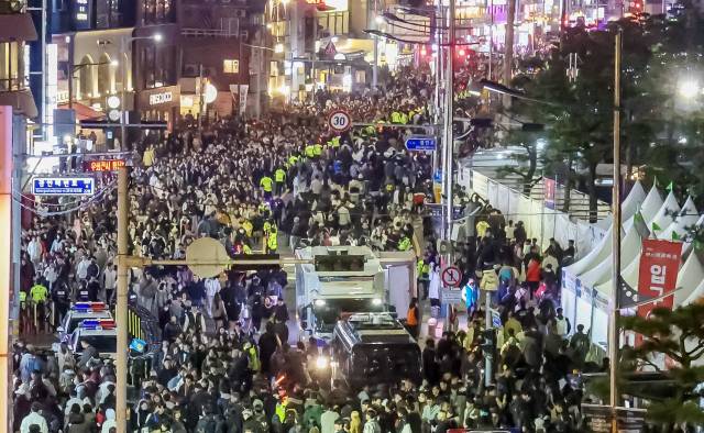 제20회 부산불꽃축제가 열린 15일 부산 수영구 광안리해수욕장 도로에서 관람객들이 귀가하고 있다. 김종진 기자 kjj1761@