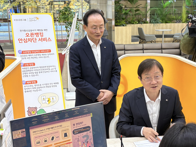 이찬진 금융감독원장(오른쪽)이 14일 서울 여의도 KB국민은행 본관에서 보이스피싱 피해 예방을 위한 ‘오픈뱅킹 안심차단서비스’에 가입하고 있다.