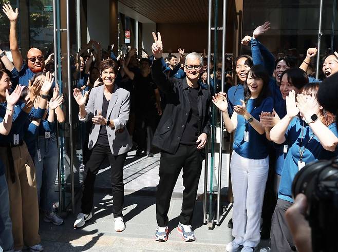 팀 쿡(가운데) 애플 최고경영자(CEO)가 9월 26일(현지시간) 일본 도쿄의 애플 긴자 스토어의 매장 재개장 기념식에 참석해 손을 흔들고 있다. AFP 연합