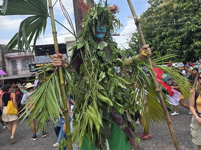 15일 브라질 벨렝에서 열린 민중정상회의 행진에 한 참가자가 나뭇잎과 덩쿨로 몸을 두르고 시위예술을 선보였다. 벨렝/옥기원 기자 ok@hani.co.kr