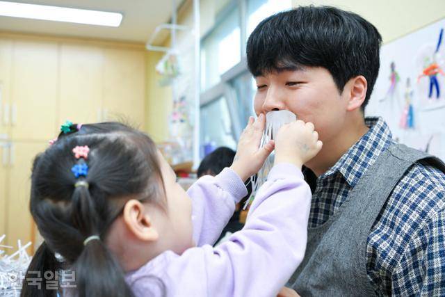 인천 부평 맑은내 어린이집에서 일하는 최요셉 교사가 10일 어린이집에서 아이가 종이로 만든 수염을 붙여주자 눈웃음을 짓고 있다. 인천=임지훈 인턴기자