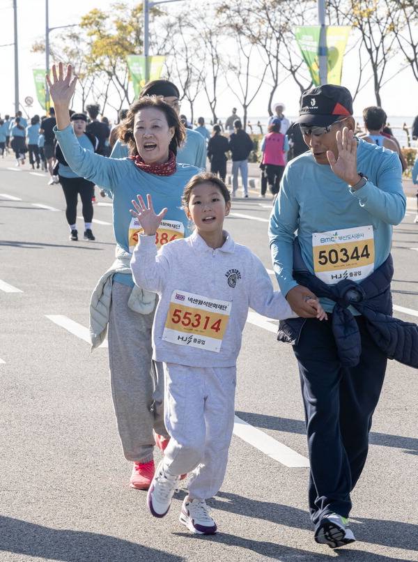 국제신문 마라톤 대회에 참여한 가족들이 달리면서 포즈를 취하고 있다.