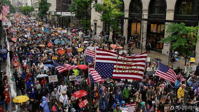 (뉴욕 로이터=뉴스1) 류정민 특파원 = 14일(현지시간) 미국 뉴욕에서 도널드 트럼프 미국 대통령의 정책에 반대하는 '노킹스'(No Kings) 시위가 열린 가운데, 시위대가 저항의 의미를 담아 성조기를 거꾸로 들고 거리 행진을 하고 있다. 이날은 성조기의 국기 채택을 기념하는 '미국 국기의 날'(플래그 데이, Flag Day)이기도 하다. 미 수도 워싱턴DC에서는 트럼프 대통령이 주재하는 미 육군 창설 250주년 군사 퍼레이드가 열린다. 2025.6.14  ⓒ 로이터=뉴스1  Copyright (C) 뉴스1. All rights reserved. 무단 전재 및 재배포,  AI학습 이용 금지. /사진=(뉴욕 로이터=뉴스1) 류정민 특파원